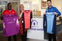 Stevenage Haven CEO Barbara Howard (second left) and Marc Campbell (far left) accept a donation of football shirts from Highfield School teacher and Hitchin Belles coach Tom Rance (right). Picture: DANNY LOO
