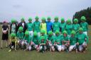 Macmillan FC players gather for their team photo sporting colourful wigs.