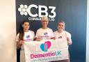 Jenny Ballantyne (centre) with her CB3 Consulting colleagues Summer Bennett (left) and Chelsea Allgood (right) holding a Dementia UK banner.
