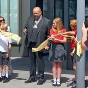 Cllr Stephen Ferguson is accompanied by pupils at Alconbury CoE Primary School to officially open New Shire Hall, Cambridgeshire County Council's headquarters.