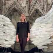 Glass-blower Layne Rowe's stunning angel wings sculpture at Ely Cathedral's Lady Chapel. Jocelyn Palmer, events manger at Ely Cathedral, in front of the installation.
