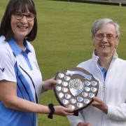Christine Wadlow (right) is presented with the Holley Shield by ladies' president Sue Tolliday, wearing the new North Cambs Bowls Club county shirt.