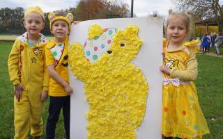 Pupils from Peckover Primary School in Wisbech with a giant Pudsey bear which they created using one and two pence coins.
